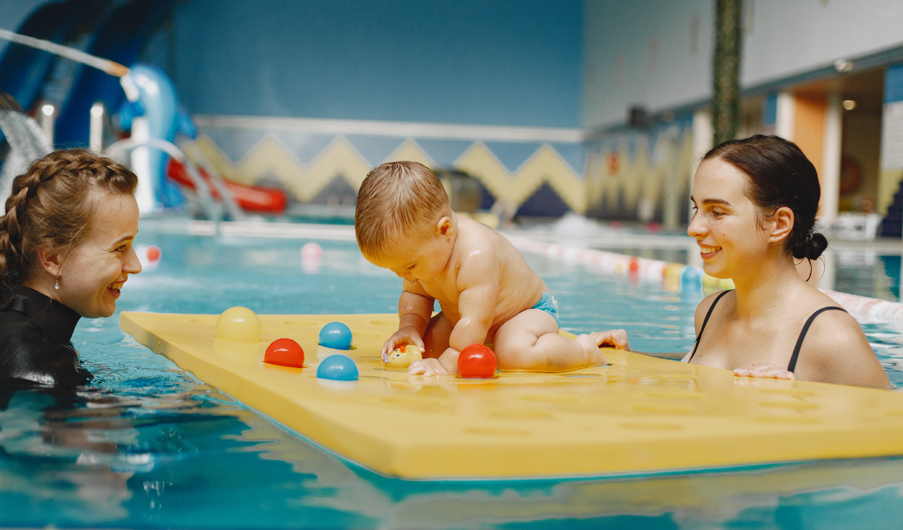 Toddler with swimming instructor in pool